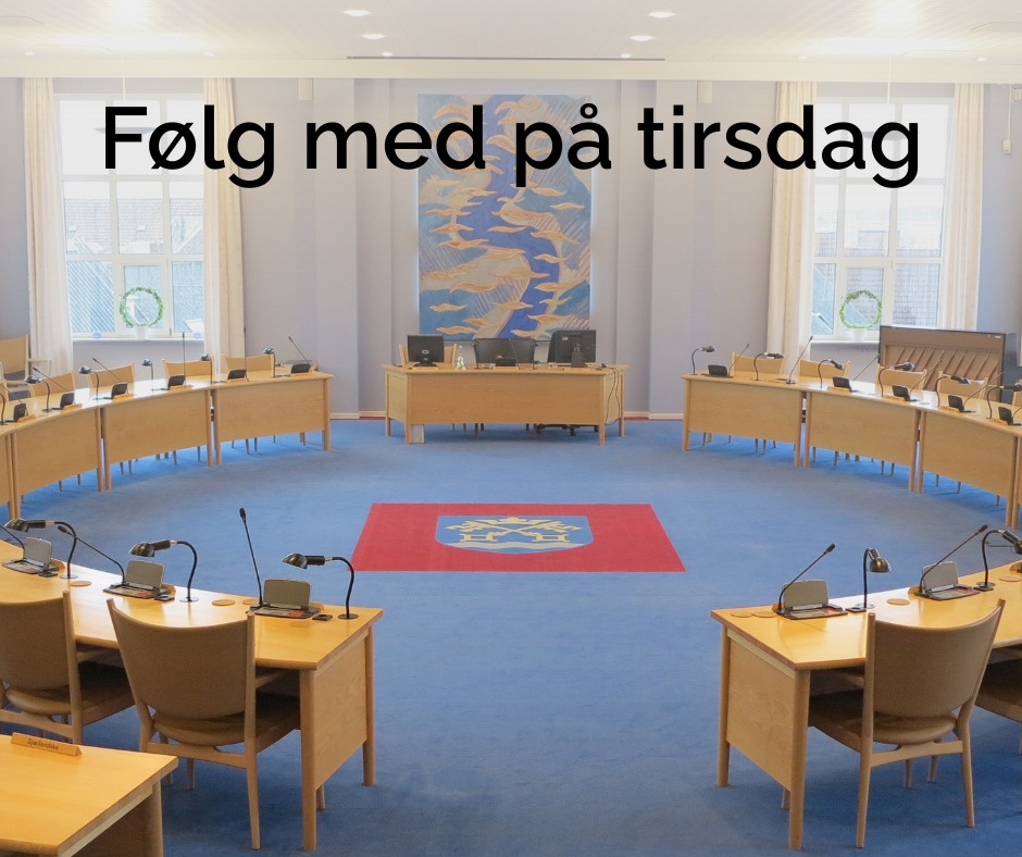 Lokale med borde i en cirkel tæppe på gulvet med Næstved Kommunes våbenskjold i midten. 